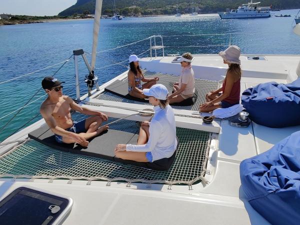 Yoga on deck of Lagoon 42 catamaran on wellness sailing holiday