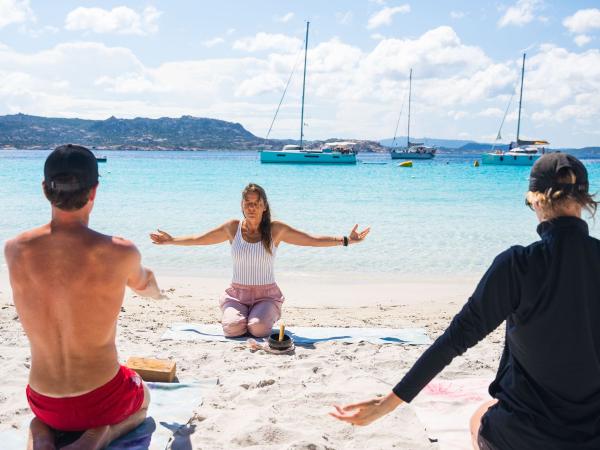 Yoga on the beach during wellness sailing holiday