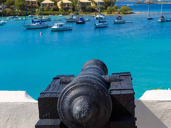 Cannon pointing at ships in the Caribbean Sea