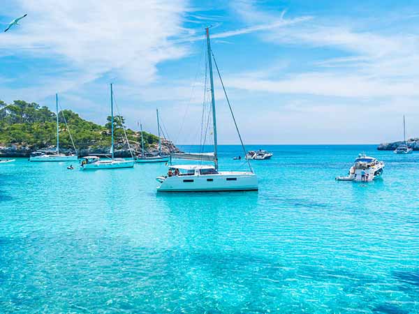 Landscape with boats and turquoise sea water on Cala Mondrago, Majorca island, Spain