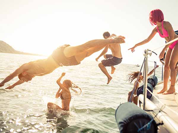 group of friends diving in the water during a boat excursion