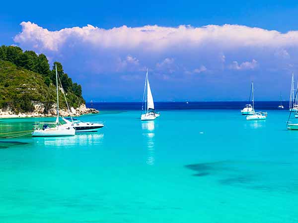 Beautiful turquoise bay Lakka in Paxos with sailing boats. Ionian islands of Greece