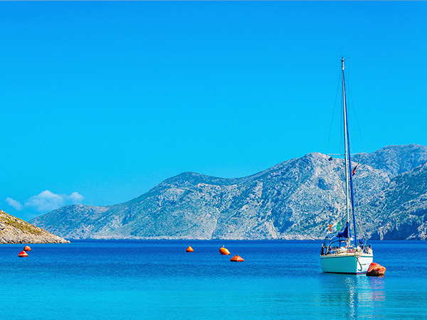 Sport yacht on anchor in silent bay on Greek Island, Greece