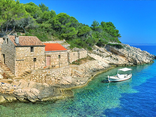 Remote bay with old stone houses and old fishing boat on the island of Lastovo, Croatia.