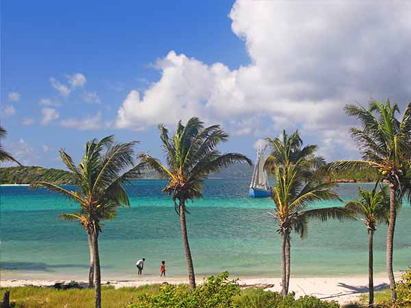 A sailing ship at a beach in the tropical paradise of the Tobago Cays.