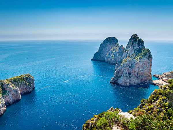 Faraglioni rocks view from hiking pass along Capri coastline , Italy.