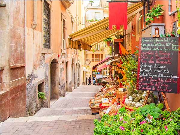 Entrance to local shop in Taormina, Sicily. Writing on the black table lists items on promotion.