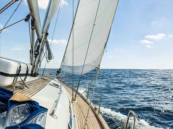 Sailing boat deck with hoisted sails and teak deck