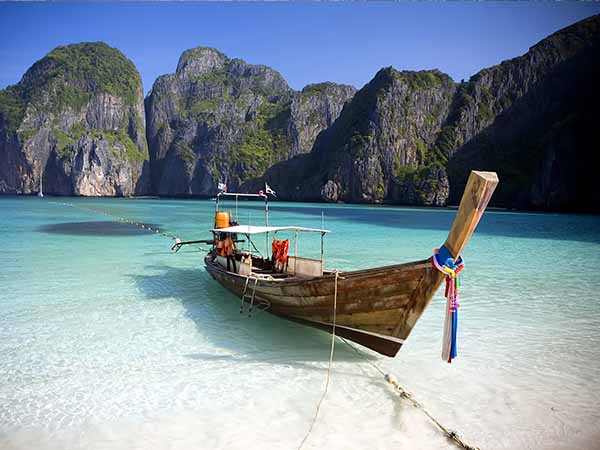 A long tail boat sits in Maya Bay, Koh Phi Phi Ley, Thailand.