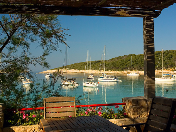 Table on terrace of exotic island beach restaurant near Hvar, Croatia